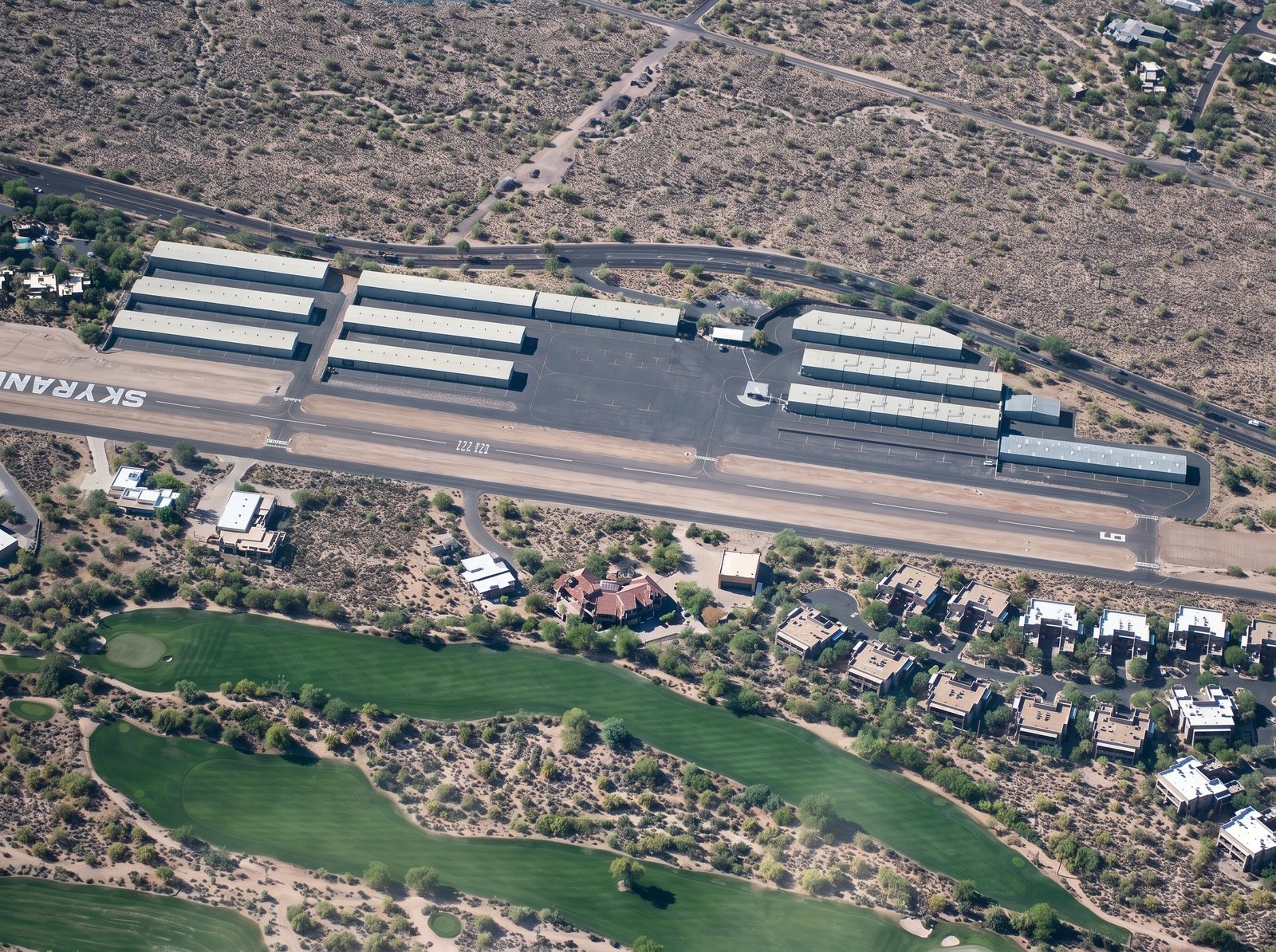 Aerial view of Sky Ranch at Carefree airpark showing the hangar rooftops CDL Roofing foam-coated in white, beside the runway and golf course